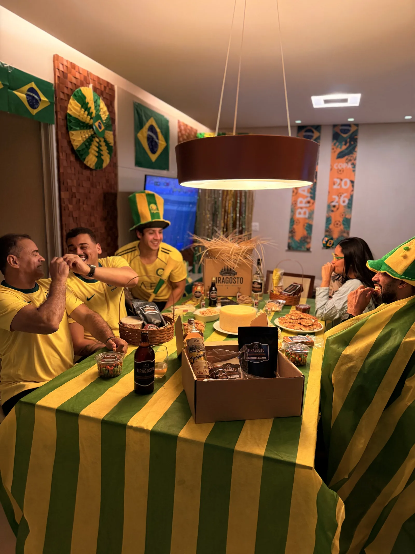 Grupo de sócios do Clube do Tiragosto reunidos em volta da mesa com produtos